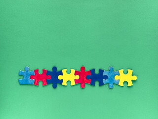 Row of colorful puzzle pieces in red, blue, and yellow, Autism World Awareness Day