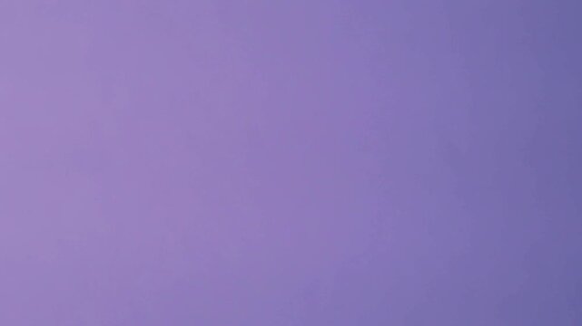 Close-up of colorful construction paper texture with soft, fluctuating shadows creating a subtle, dynamic background loop.