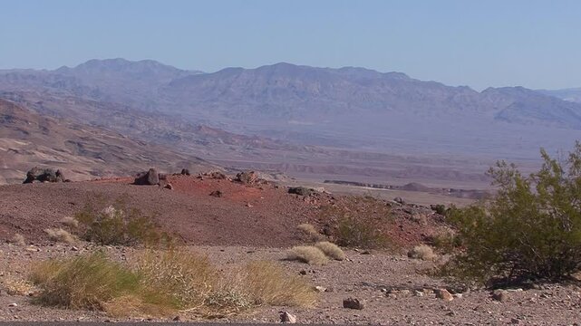 The view from near Towne Pass of the Panamint Mountains on the east side of Panamint Valley, California, near Death Valley National Park, with a foreground of desert grass, creosote and volcanic rock.