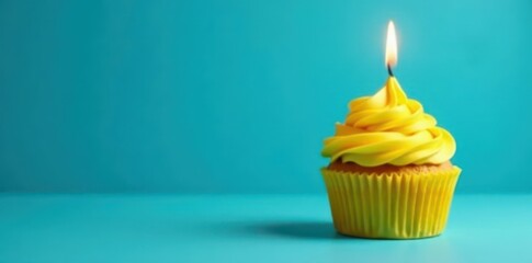 A single yellow cupcake with a lit candle against a blue background , gastronomy, festive