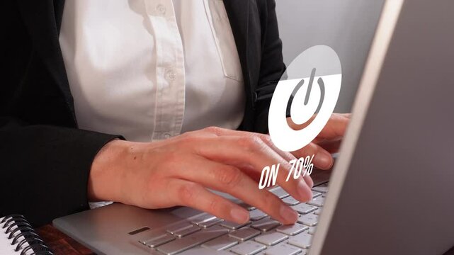 Animation of the power icon filling with progress from 0 to 100%, a woman working on her computer in the background