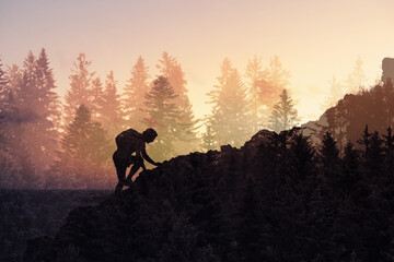 silhouette of a man climbing up to the mountain top, reaching your goals, never give up concept 