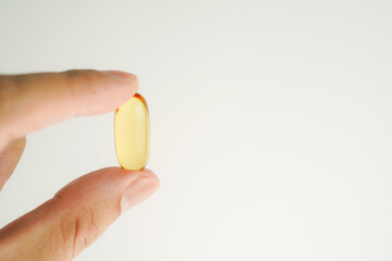 Male hand holding Oil filled capsules, softgel of food supplements, fish oil, omega 3, vitamin E