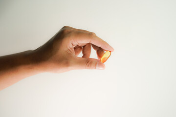 Male hand holding Fish oil capsules with omega 3, omega 9, vitamin D, vitamin E, Cod liver oil