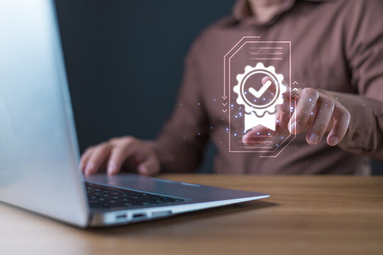 A businessman interacts with a glowing digital icon of a certificate featuring a checkmark, symbolizing quality assurance and trust in digital standards, service, or performance.