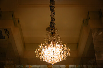 Elegant chandelier hanging from the ceiling, adding a warm glow and classic charm to the interior space. Perfect for luxury homes, hotels, or refined interior design.