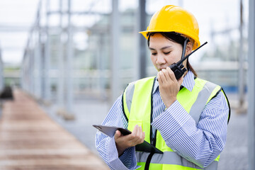 Engineer is working at high voltage power substation conducting inspection and check of...