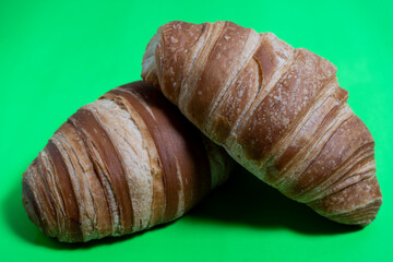 Flaky croissant product shot on emerald green