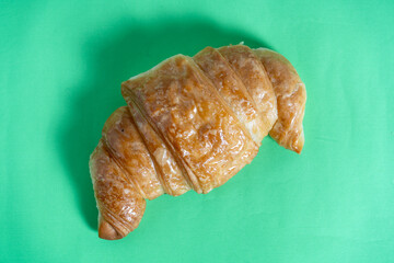 Artisanal croissant on deep green background