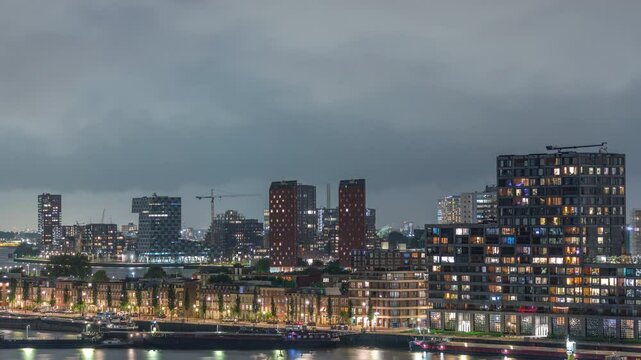 Panoramic aerial day to night transition timelapse of Katendrecht peninsula and Maashaven harbour in Rotterdam, The Netherlands. City skyline modern skyscrapers and traditional Dutch waterfront houses