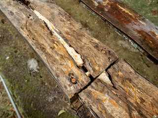 two wooden planks with rusty nails attached to make a simple traditional chair