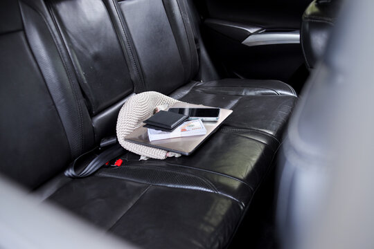 Bag, Wallet, Phone And Cash On The Back Seat Of Vehicle Potential Target For Theft