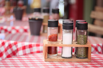 Condiment set with spices and herbs on a restaurant table