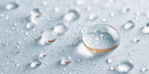 Close-up of water droplets on a surface, showcasing reflections and textures, highlighting the beauty of liquid and light.
