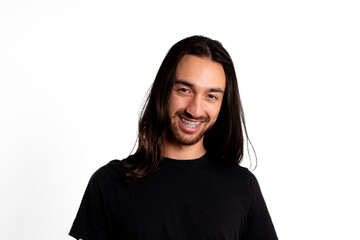 Young adult man, Latino, with braces, smiles looking at the camera against white background