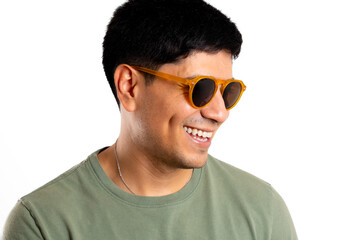Young smiling Latin man looks away, on white background, wearing sunglasses
