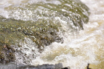A serene river flows powerfully through a lush, waters cascading down a mountain slope,Red flood water flows from the mountains, Nature of forests and red streams formed by the previous heavy rain