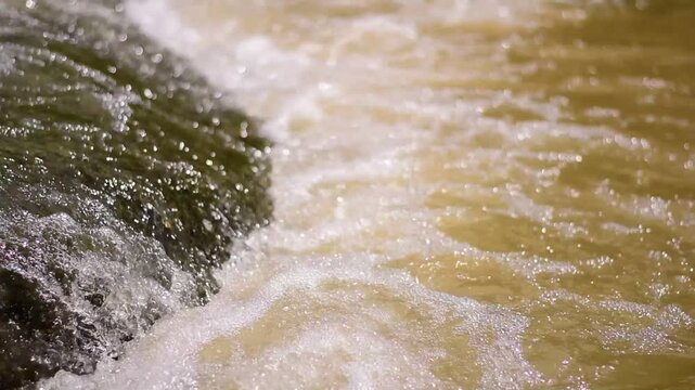A serene river flows powerfully through a lush, waters cascading down a mountain slope,Red flood water flows from the mountains, Nature of forests and red streams formed by the previous heavy rain