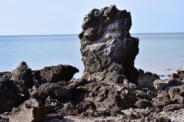 waves crashing on rocks, Rocks and trees on the coast, sea with rocks and sand. Travel photo
