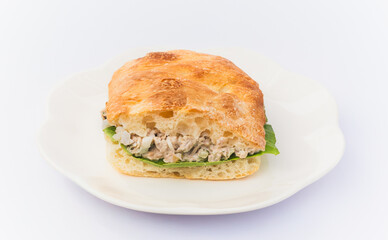 Tuna salad sandwich with lettuce on ciabatta bread in white background.