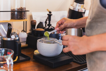 Woman preparing a Japanese Matcha green tea in a coffee shop.