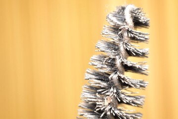 The intricate details of a mascara brush, showcasing its densely packed bristles designed to coat and separate eyelashes. 