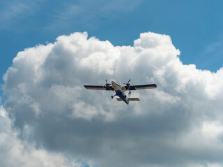 夏の空を飛ぶ双発プロペラ機