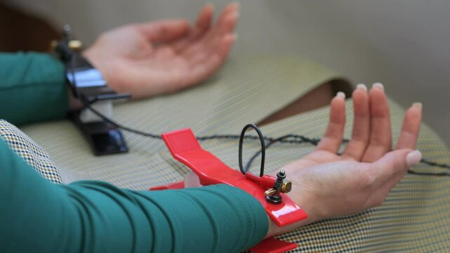 Woman is wearing a red wrist strap and has her hands tied behind her back. Concept of restraint and captivity