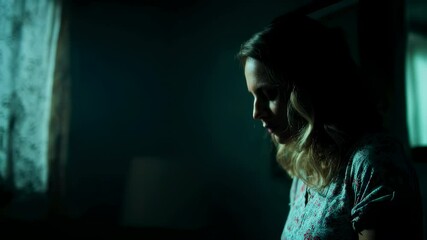 Pregnant woman standing near window with soft curtains, casting contemplative silhouette in shadowy room, embodying deep emotional journey of maternal anticipation