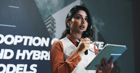 Presentation, speech and tablet with Indian woman at symposium for hybrid business models. App, event and podium with corporate speaker in auditorium for introduction to remote work development