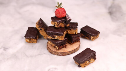 Choco Chip Cookie Brownies are decadent brownie-cookie hybrids featuring a chewy brownie layer stacked over a crunchy chocolate chip cookie base, all coated in a smooth chocolate ganache. Each bar off