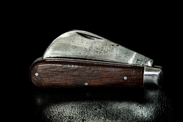 Vintage well used Hawkbill pocket knife with hardwood handle reflecting an era when tools were built by craftsman and built  to last.