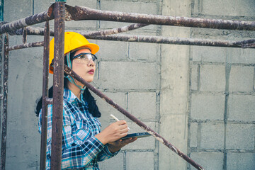 Young female project manager supervising construction work at residential building project.
