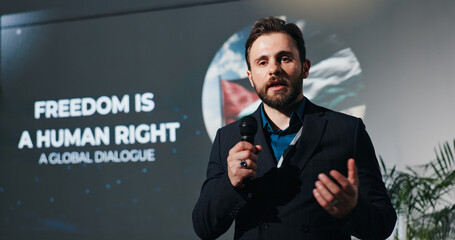 Man, presentation and human rights at convention on stage for talk, freedom or info at event. Person, public speaking and discussion at global conference for equality, accountability or peace in Gaza © peopleimages.com