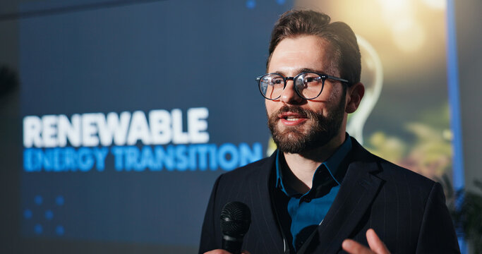 Microphone, presentation and businessman on a stage at conference for renewable energy transition. Public speaker, seminar and male environmental manager at convention, workshop or tradeshow.