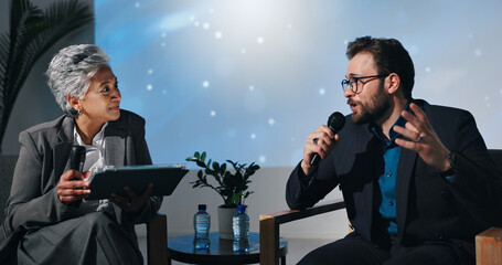 Presentation, guest and people with mic, talking and businessman with investment strategy and ideas. Chat, host and woman with tablet for questions, conversation and listening to entrepreneur in show
