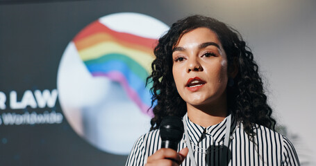 Naklejka na ściany i meble Microphone, presentation and stage with woman in auditorium for speech on worldwide lgbt laws. Awareness, community or gender equality and speaker on podium with rainbow flag for gay rights or pride
