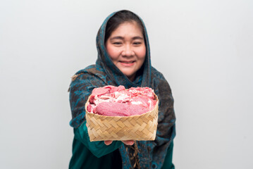Smiling Woman in Teal Presents Fresh Meat in Woven Basket