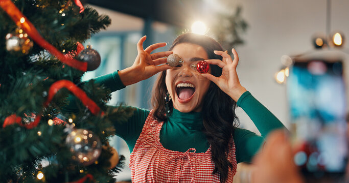 Christmas tree, funny and picture with woman and ornament for festive season, memory and decoration. Merry xmas, holiday and photography with silly person in living room of home for happy and bauble