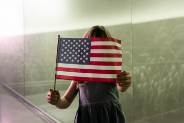 a little girl holding a flag in front of a mirror