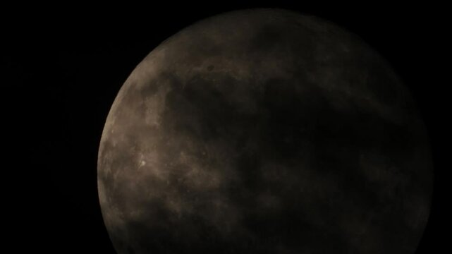 Dark clouds shroud full moon, casting black, eerie, and scary scene