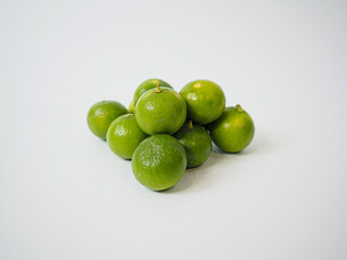 Bunch of fresh whole limes arranged closely with slight randomness to create visual impact for...