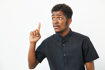 African American man with a thoughtful expression, raising his finger in a gesture, showcasing...