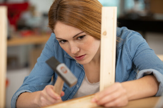 happy young woman nailing a chair