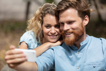 Fototapeta premium joyful loving couple making selfie on camera