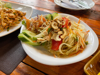 Thai papaya salad. Green papaya salad on the table in a restaurant, Thailand.
