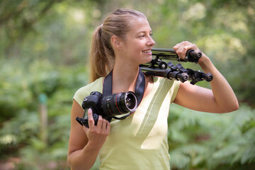 female photographer in the countryside with a camera and tripod