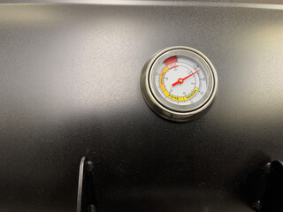 Close-up of the thermometer on the grill lid.