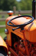Close-up of vintage orange tractor, black steering wheel. Agricultural machine in farming. Powerful diesel engine equipment for heavy duty field work.