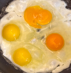 A frying pan with three eggs in it